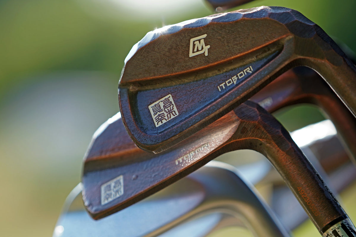 Close-up of golf iron heads showing the neck and hosel where the shaft joins the clubhead